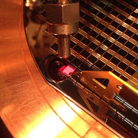 Multi-junction solar cell testing. When electrical current is injected in the solar cell, it emits light – bright red in the case of a GaInP solar cell – that can be collected and analysed with a probe. Devices fabricated at the Fraunhofer Institute of Solar Energy Systems, Germany (http://www.ise.fraunhofer.de).