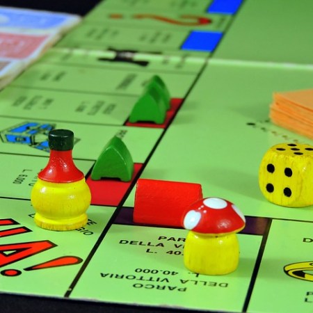 Corner of a monopoly board with playing pieces and dice